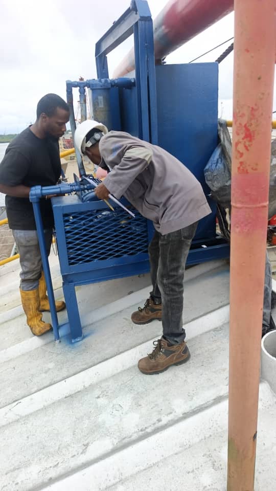 Technicians servicing drilling equipment